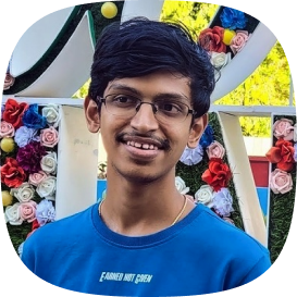 vishal, grinning in front of some flowers